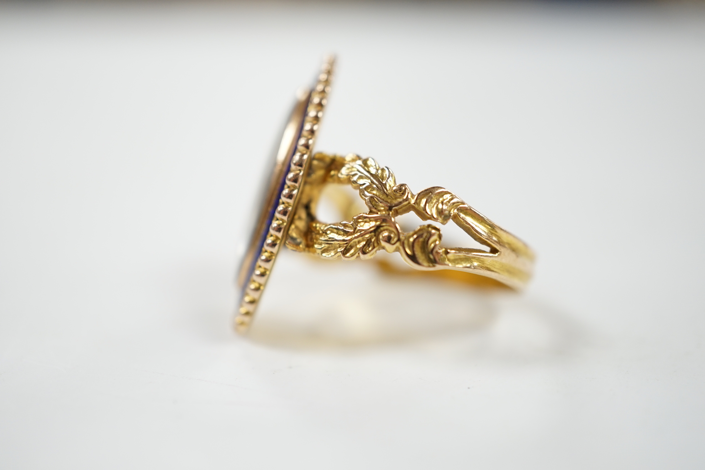 A 19th century 15ct and blue enamel set navette shaped mourning ring, with damaged inset ivory panel, size O, gross weight 5.5 grams. Submission reference Q8ZGC6ZR